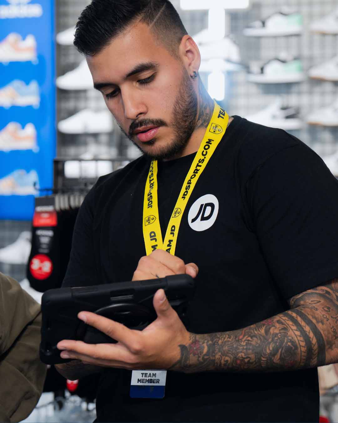 employé de chez JD Sports qui conseille un client